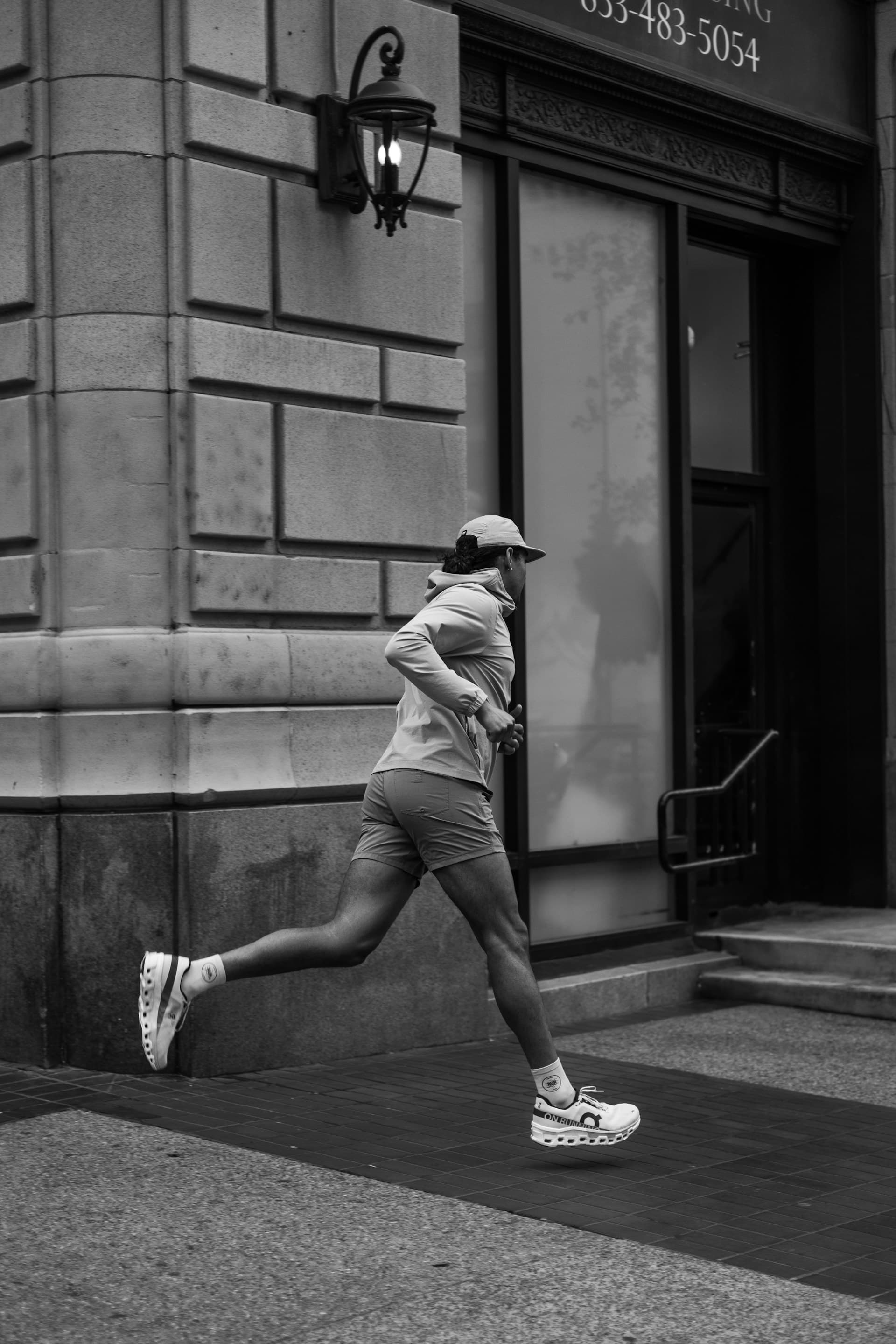 Coureur en veste jaune fluo courant dans une rue en ville